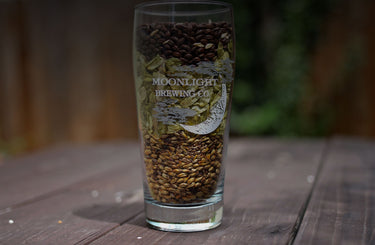 Moonlight Brewing pint glass with various ingredients layered inside