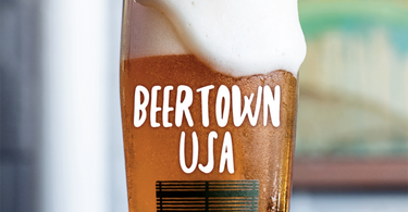 glass with beer pouring over that says Beertown USA