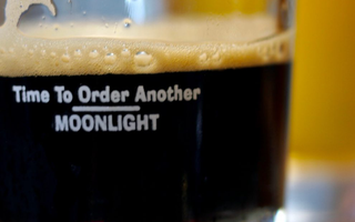 Almost empty glass of dark beer with message, "Time to Order Another Moonlight"