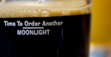 Almost empty glass of dark beer with message, "Time to Order Another Moonlight"